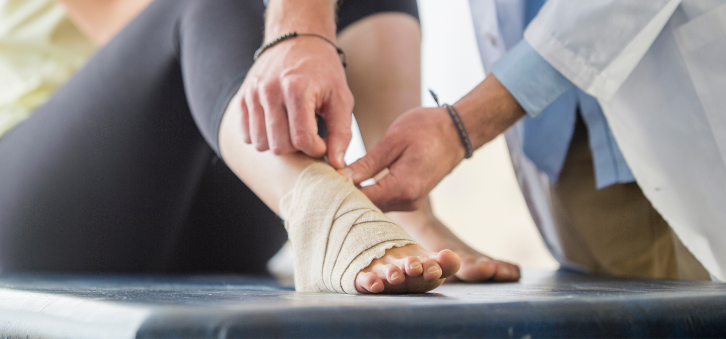 Doctor wrapping up a person's ankle